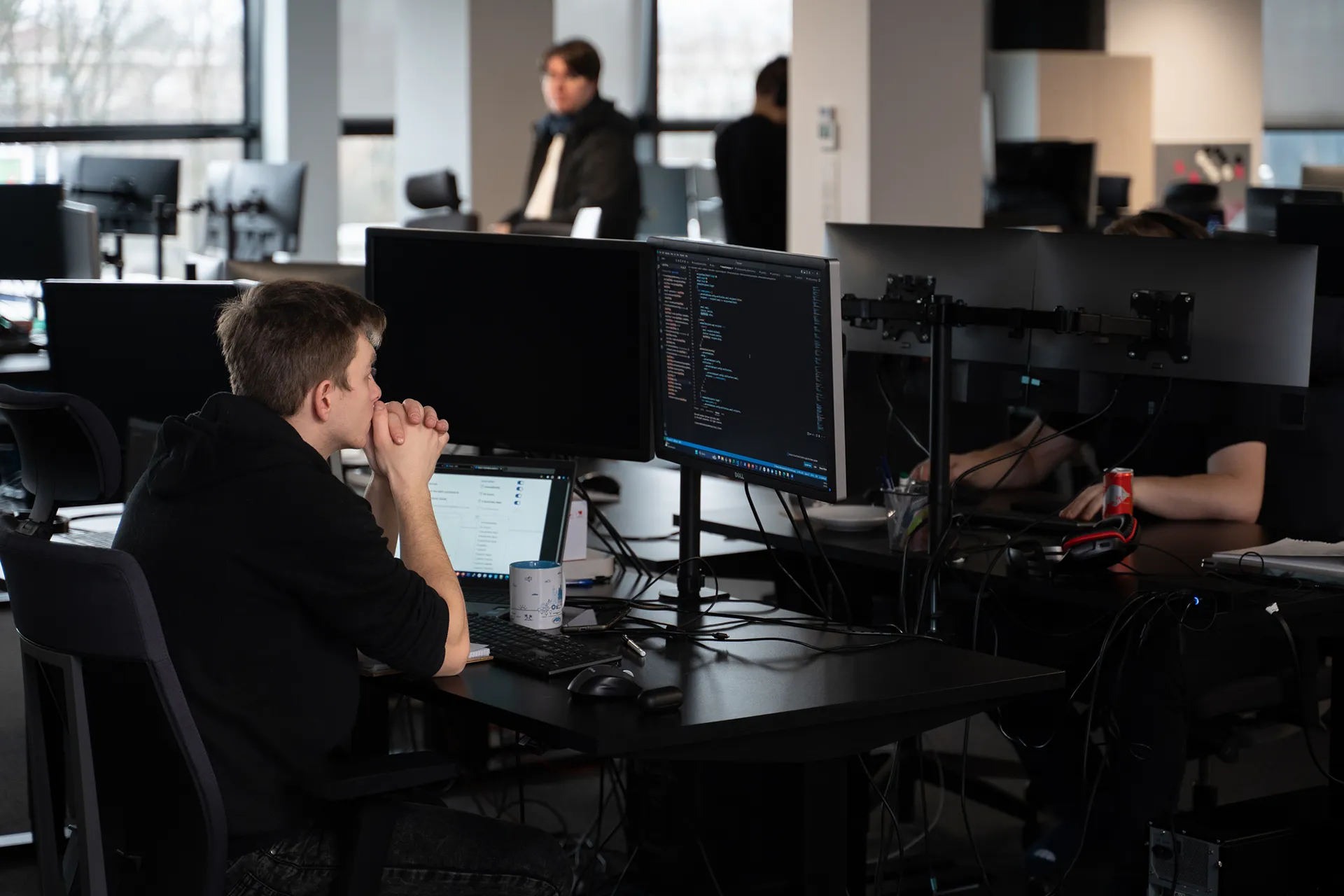 A programmer actively developing a web application, focusing on coding and troubleshooting, with a computer screen displaying lines of code or design elements.